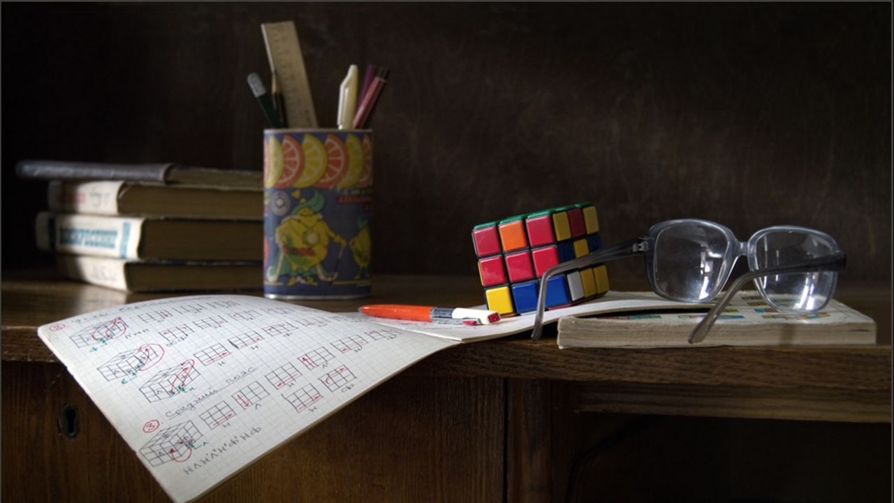 Обои стол, очки, инструкция, кубик рубик, ручки, линейка, книги