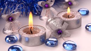 Превью обои свечи, колокольчики, елочные игрушки, мишура, атрибуты, рождество, новый год, праздник