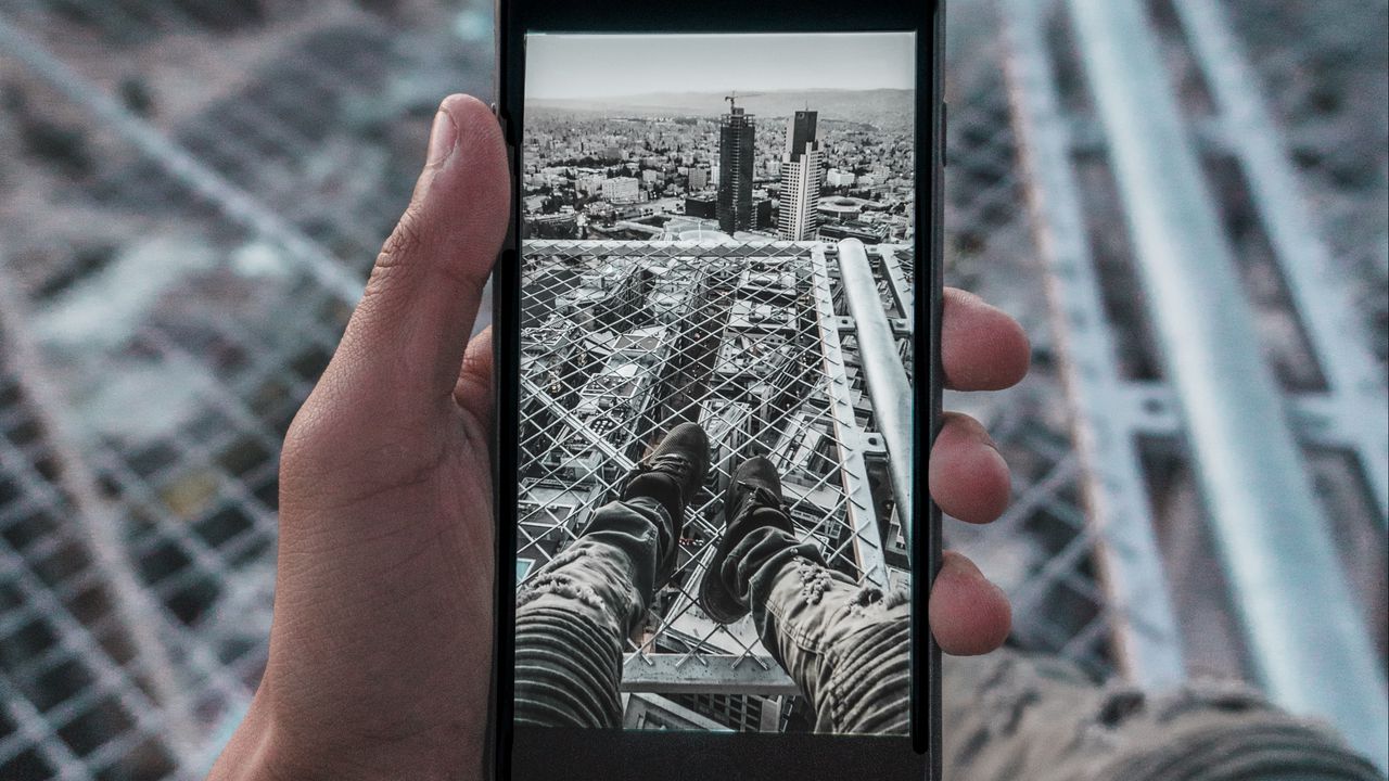 Обои телефон, рука, фото, крыша, город, вид сверху