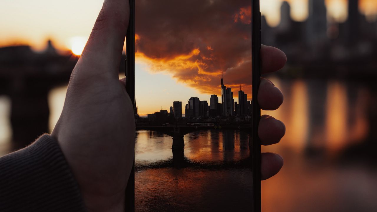 Обои телефон, снимок, фото, рука, город, закат