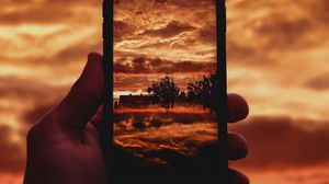 Превью обои телефон, снимок, фото, облака, деревья, пейзаж, темный