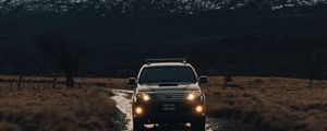 Превью обои toyota, автомобиль, внедорожник, вид спереди, скалы, дорога
