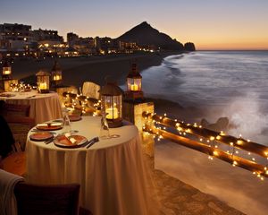 Превью обои вечер, стол, ужин, ресторан, побережье, вид, огни, гирлянда