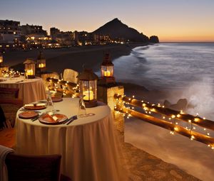 Превью обои вечер, стол, ужин, ресторан, побережье, вид, огни, гирлянда
