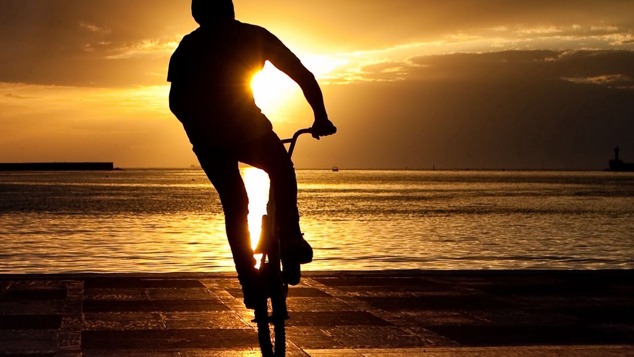 Обои велосипедист, трюк, прыжок, экстрим, солнце, набережная