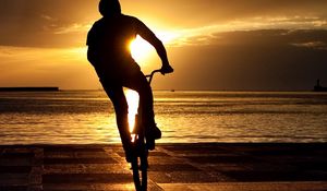 Превью обои велосипедист, трюк, прыжок, экстрим, солнце, набережная