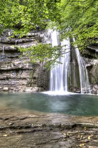 Превью обои водопад, дерево, ветка, скалы, струи, листья