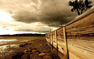 Превью обои забор, камни, море, берег, удочки